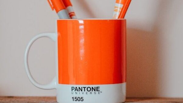 markers in mug on brown surface